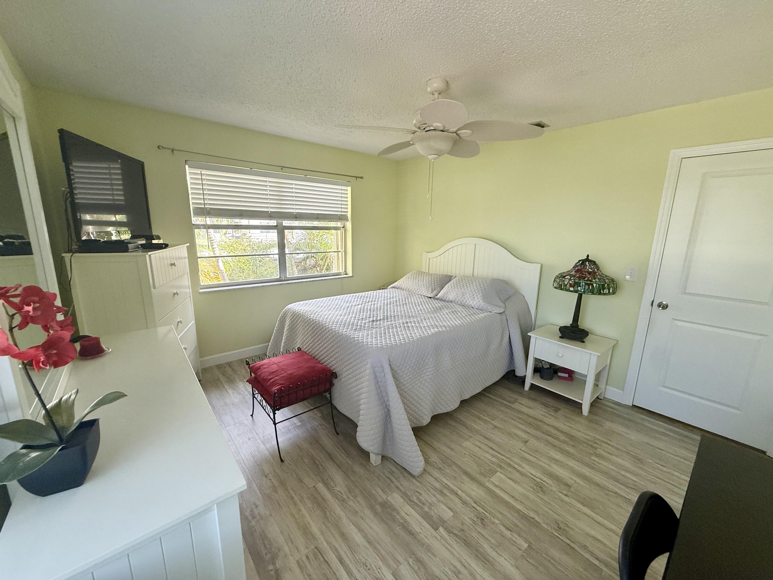 1982 Southwest Palm City Road, Unit F Stuart, FL 34994 - Photo 15 of 34 a bedroom with a bed and a potted plant