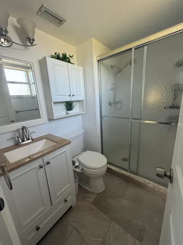 a bathroom with a granite countertop sink toilet and shower