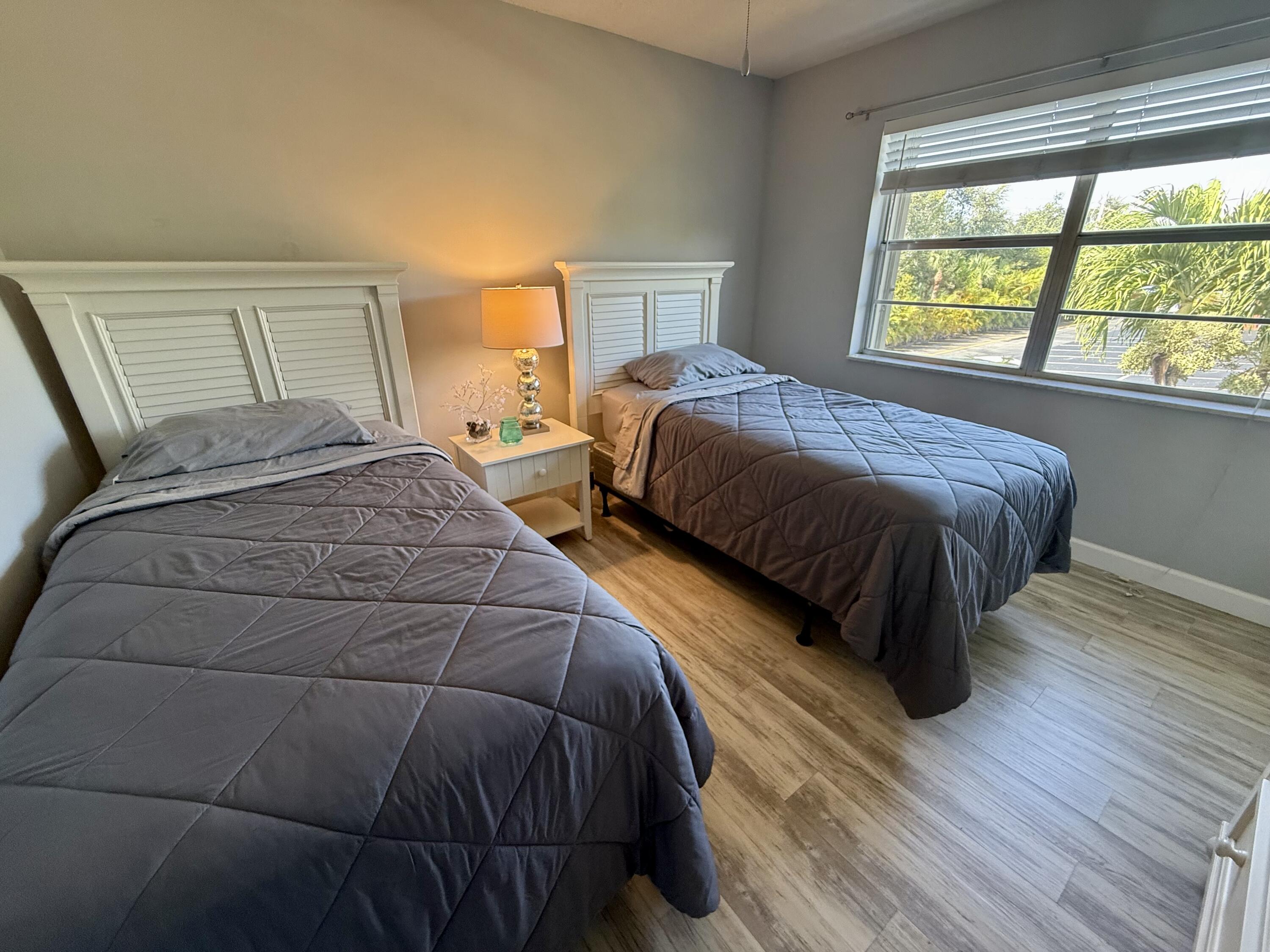 1982 Southwest Palm City Road, Unit F Stuart, FL 34994 - Photo 17 of 34 a bedroom with a bed and a large window