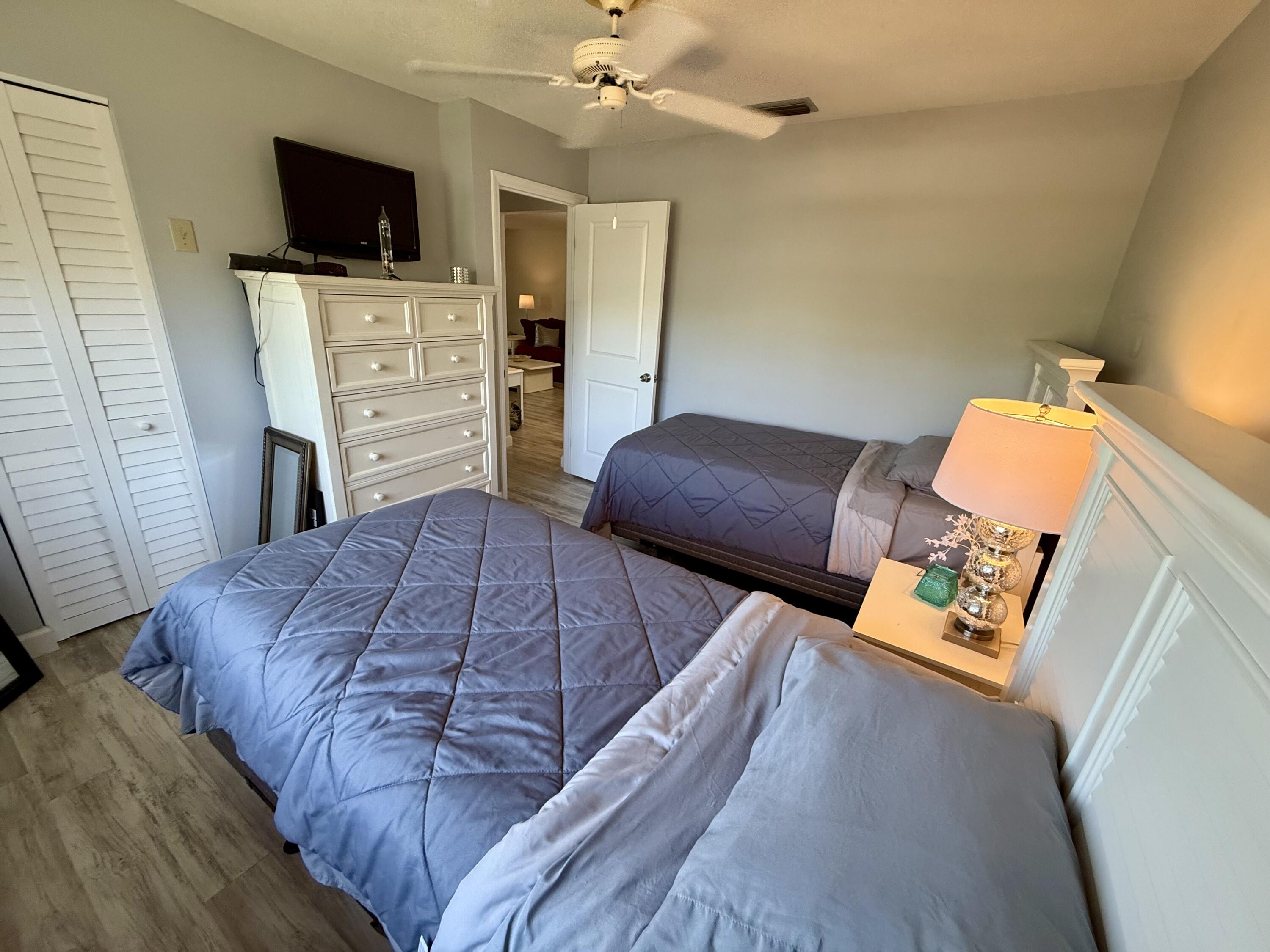 1982 Southwest Palm City Road, Unit F Stuart, FL 34994 - Photo 18 of 34 a bedroom with a bed and flat screen tv