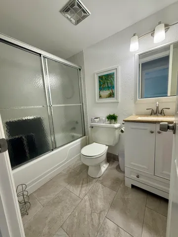 a bathroom with a toilet a sink a mirror and a shower