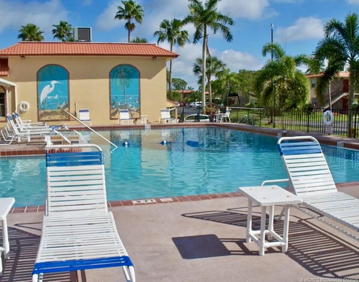 1982 Southwest Palm City Road, Unit F Stuart, FL 34994 - Photo 25 of 34 a view of a patio with table and chairs potted plants with palm trees