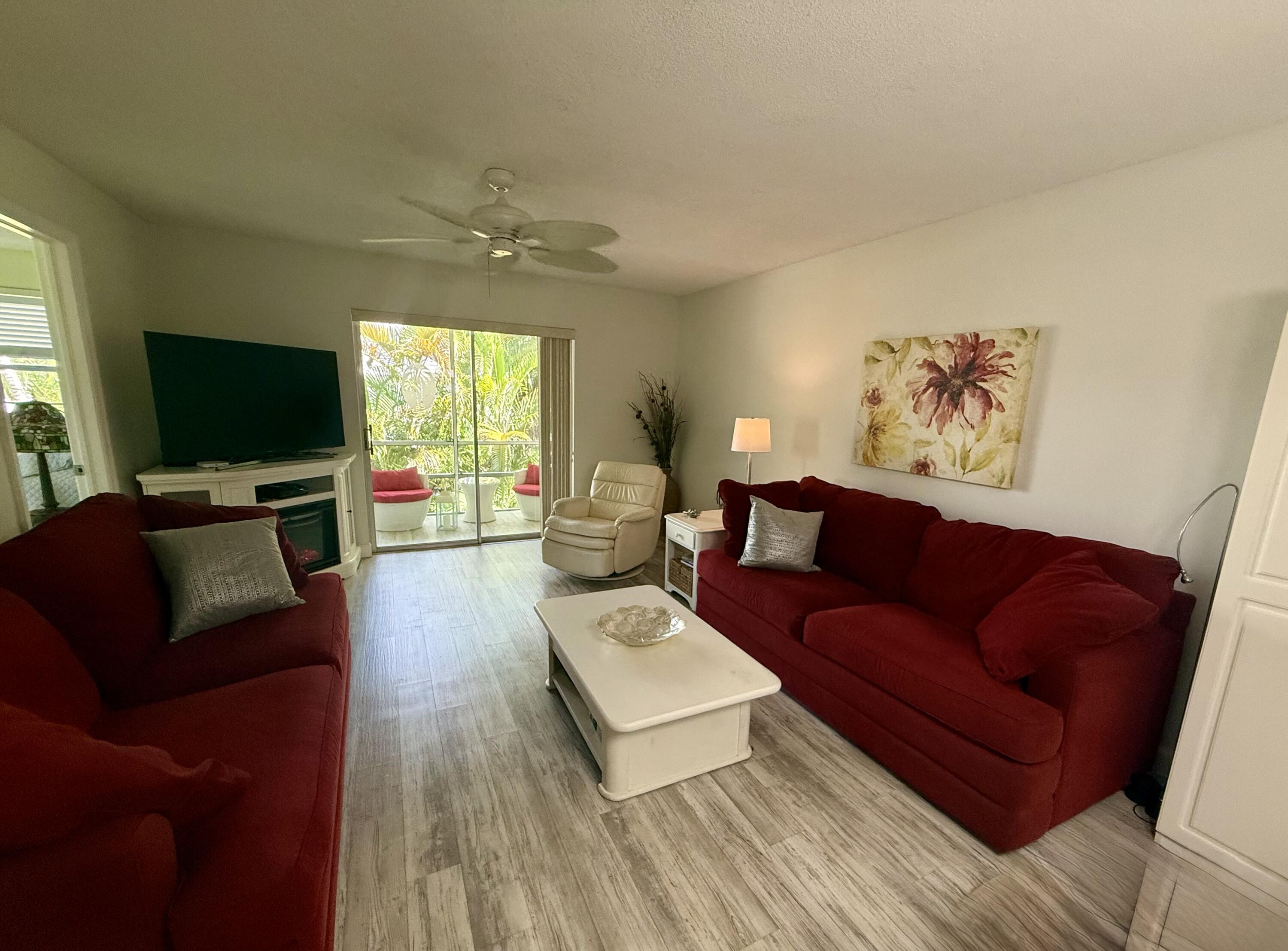1982 Southwest Palm City Road, Unit F Stuart, FL 34994 - Photo 7 of 34 a living room with furniture and a flat screen tv