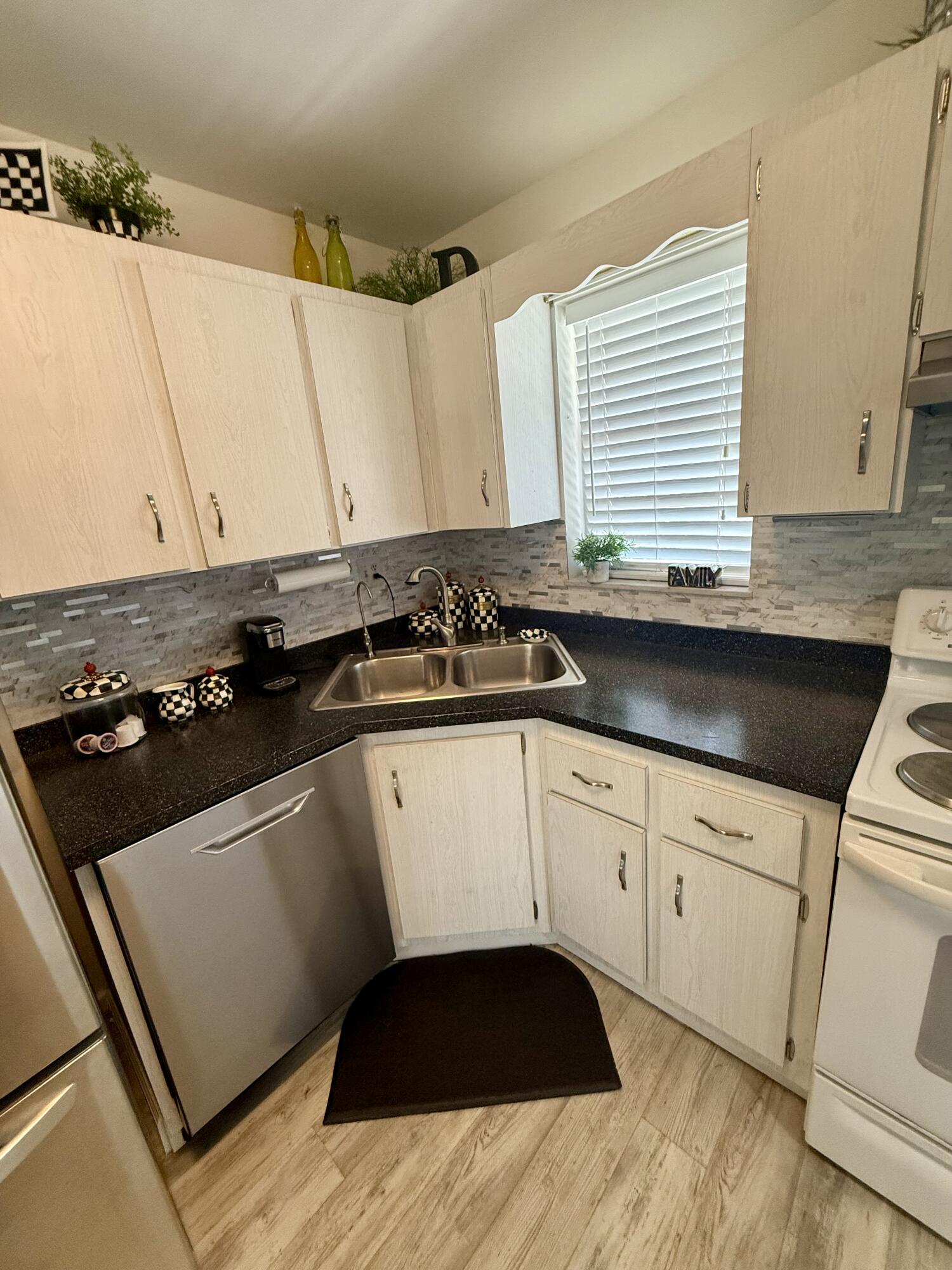 1982 Southwest Palm City Road, Unit F Stuart, FL 34994 - Photo 9 of 34 a kitchen with a sink a stove and white cabinets