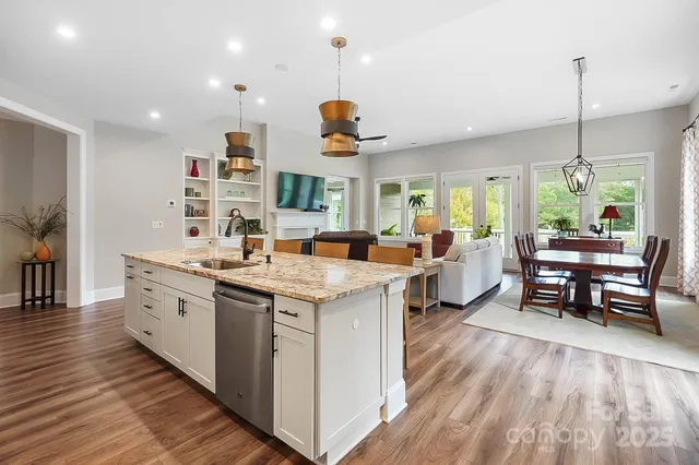 a open kitchen with stainless steel appliances granite countertop a stove and wooden floor