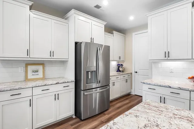 a kitchen with a refrigerator stove and white cabinets