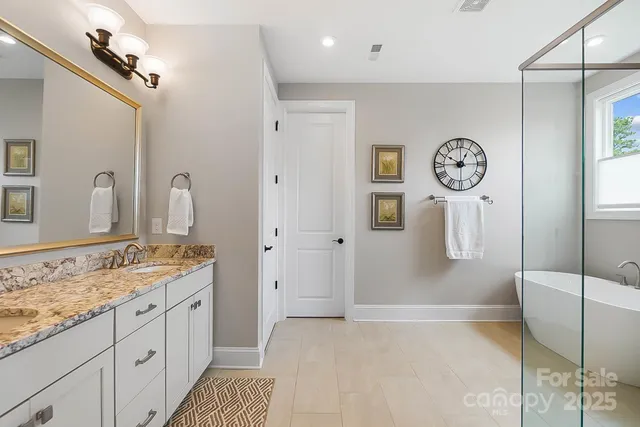 a spacious bathroom with a granite countertop sink a mirror and shower