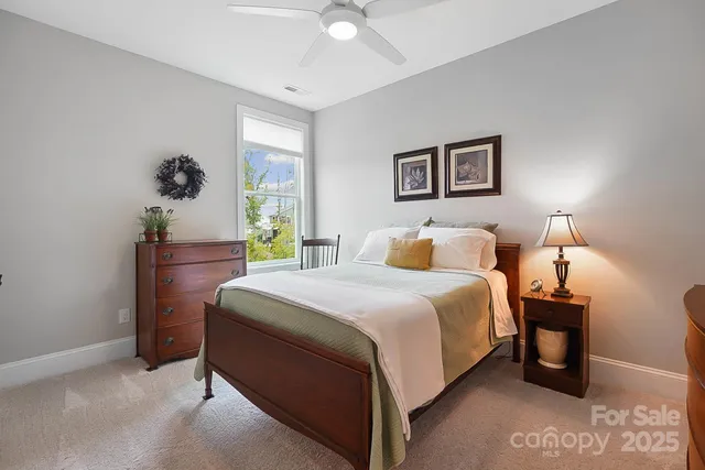 a bedroom with a bed and a lamp on dresser