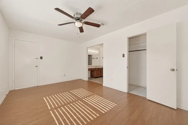 a view of a livingroom with wooden floor and a ceiling fan