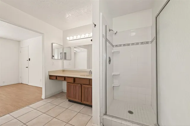 a bathroom with a granite countertop sink mirror and shower
