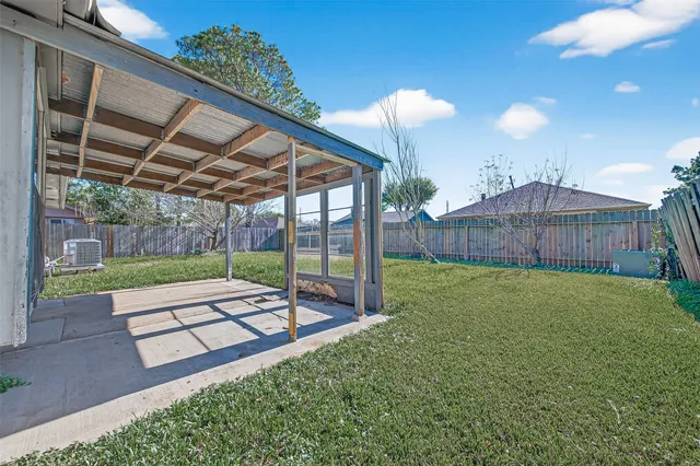 a view of a backyard with table and chairs with wooden fence