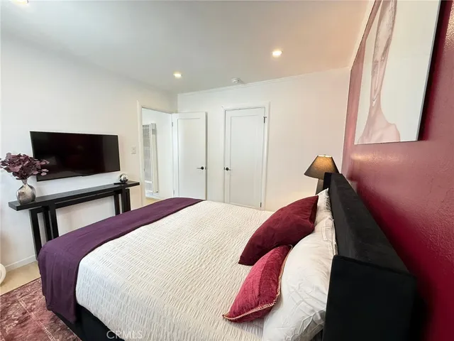 a bedroom with a bed and a flat screen tv