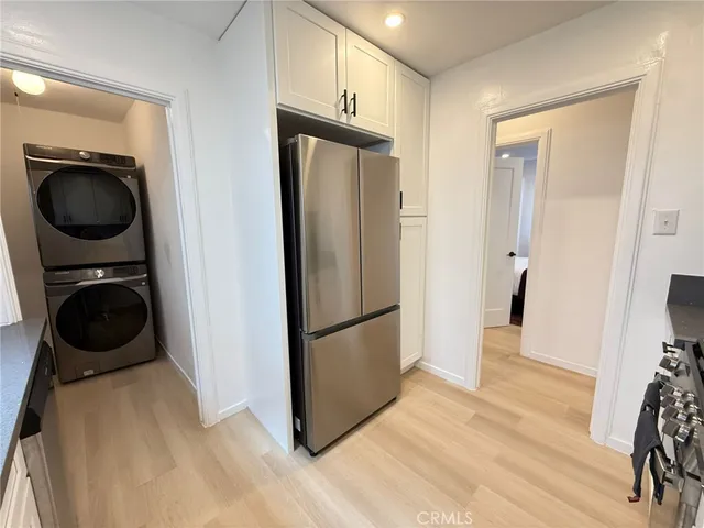 a kitchen with a refrigerator and a wooden floor