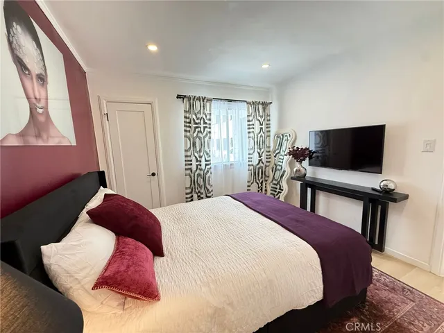 a bedroom with a bed and a flat screen tv