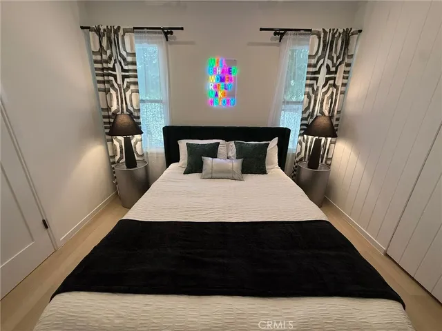 a bed sitting in a bedroom next to a window with pc on the wall