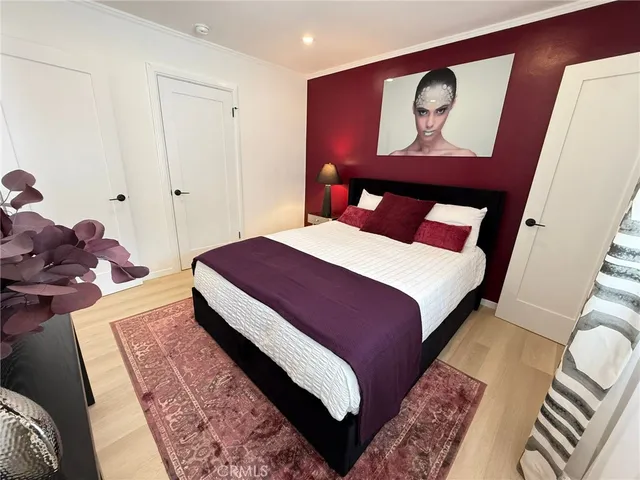 a bedroom with a bed and a painting on the wall