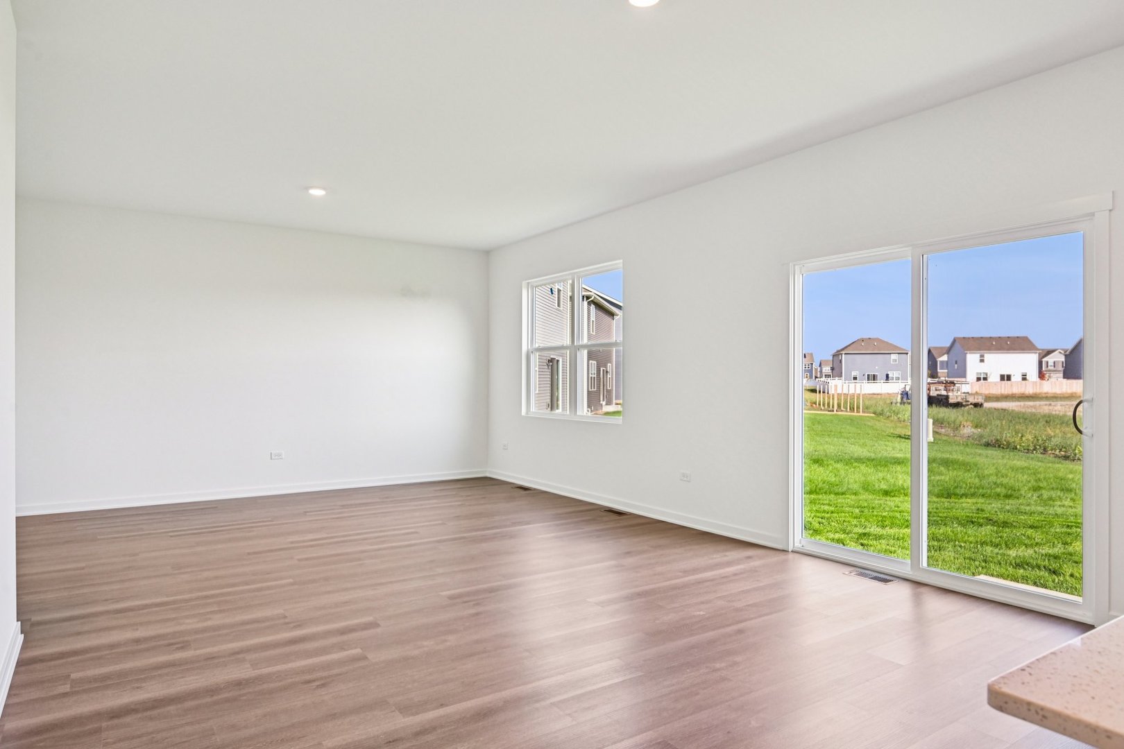 6722 Applegate Drive Plainfield, IL 60586 - Photo 16 of 45 a view of an empty room with a window and wooden floor