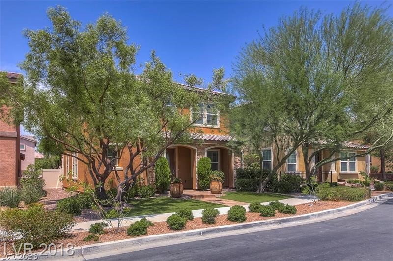 3144 Whitfeild Avenue Henderson, NV 89044 - Photo 2 of 55 A terracotta-hued facade is softened by mature desert-adapted trees and carefully maintained landscaping.