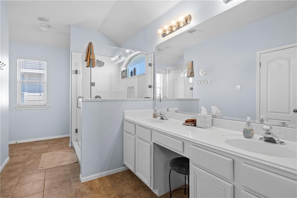 3508 Bratton Ridge Crossing Austin, TX 78728 - Photo 12 of 18 Dual vanity sinks provide ample space in this well-lit primary bathroom with a glass-enclosed shower.