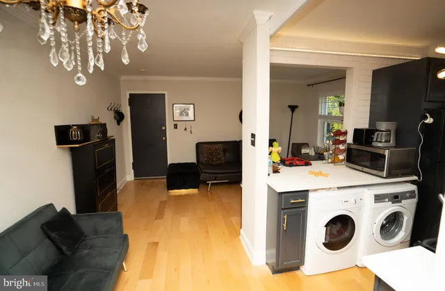 a living room with stainless steel appliances kitchen island a table and chairs in it