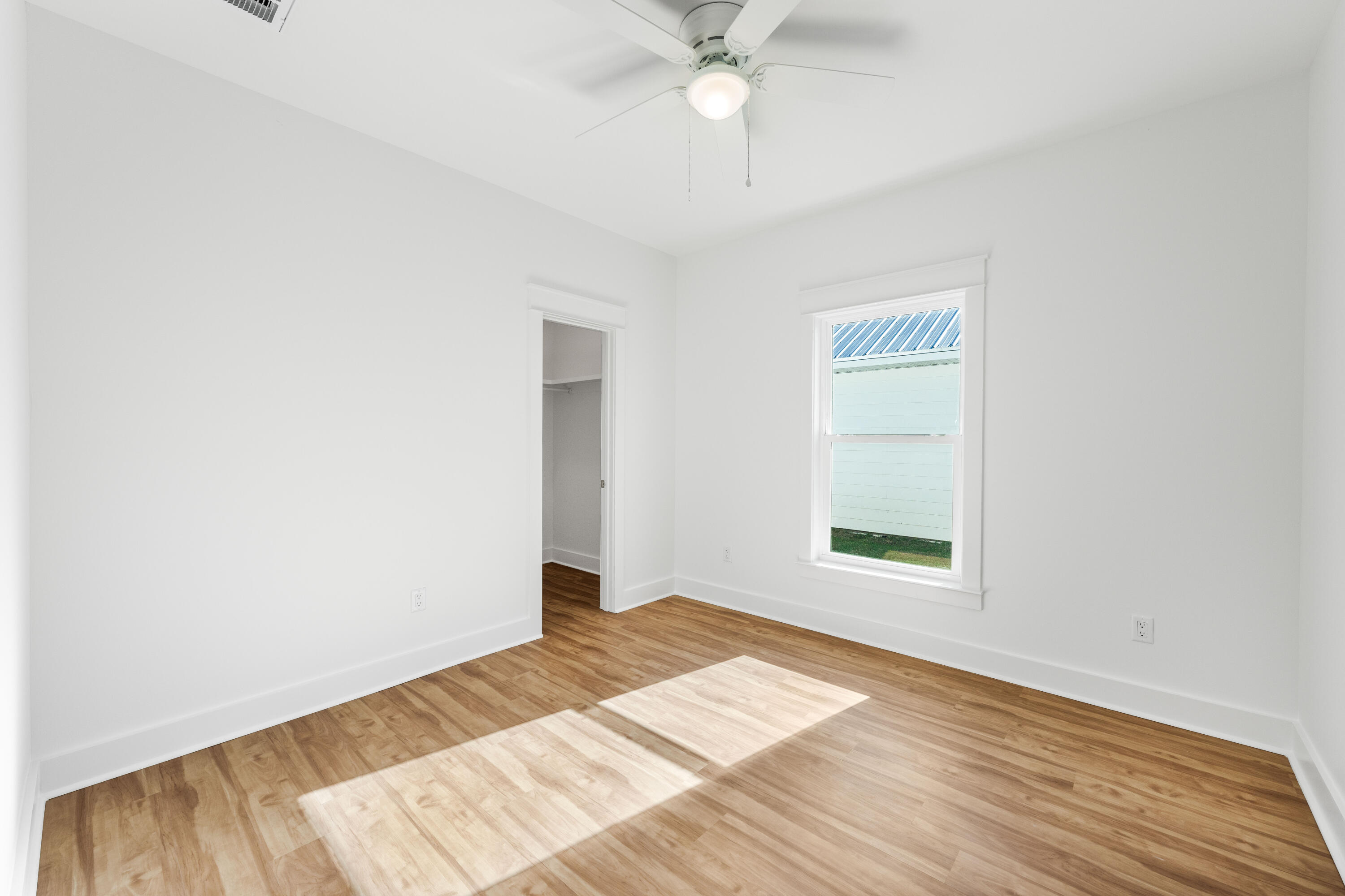 103 Fletcher Way Destin, FL 32541 - Photo 26 of 30 an empty room with wooden floor fan and windows