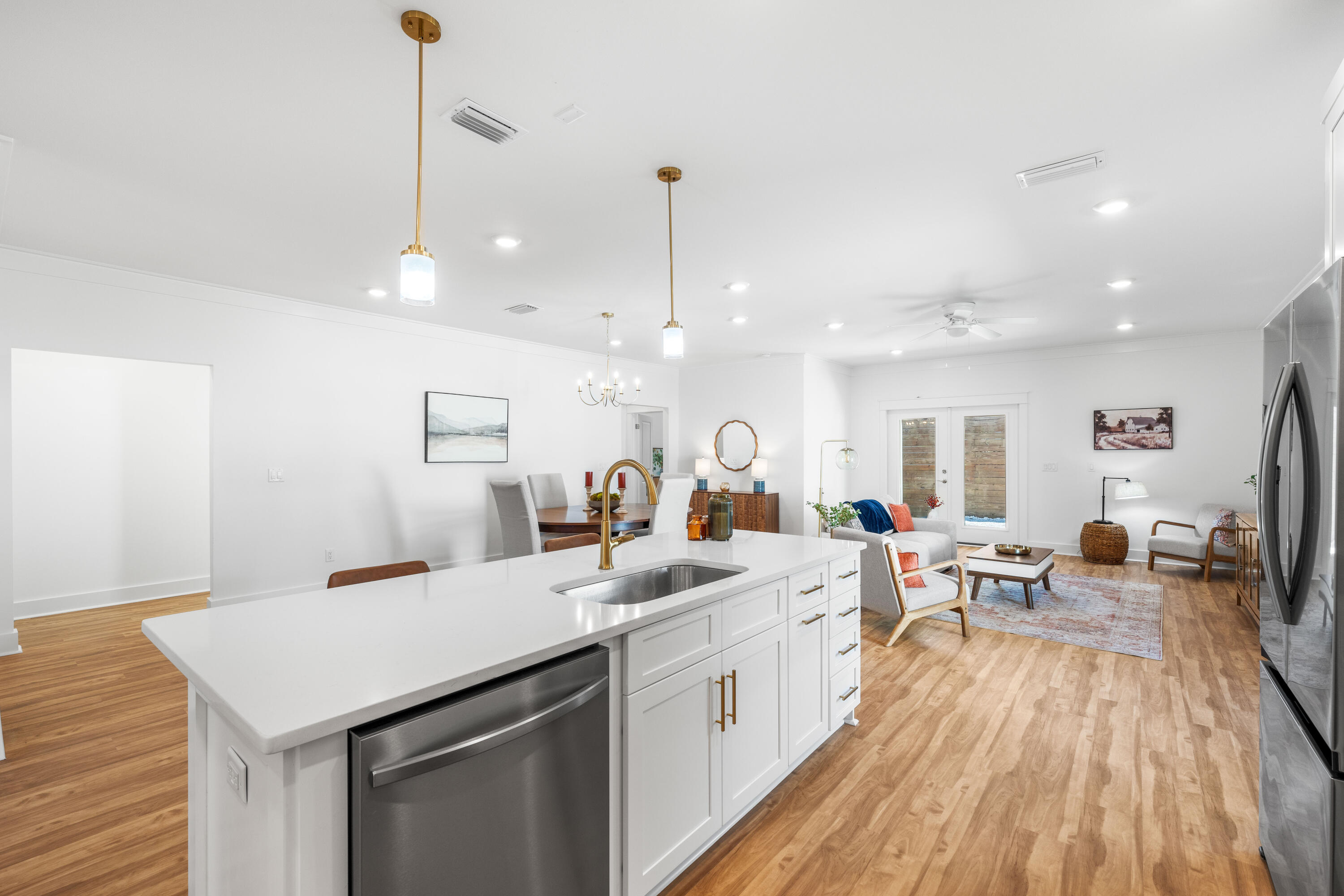 103 Fletcher Way Destin, FL 32541 - Photo 7 of 30 a large white kitchen with a sink a counter space appliances and wooden floor