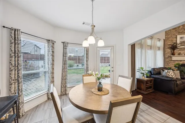 a dining room with furniture a chandelier and wooden floor