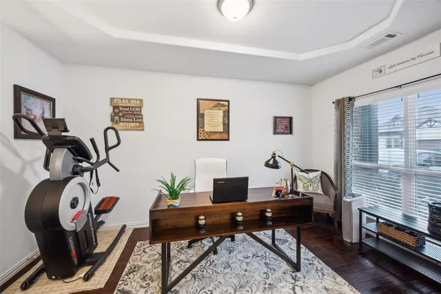 a view of a workspace with furniture and a window