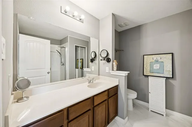 a bathroom with a granite countertop sink toilet and shower