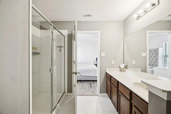 a en suite bathroom with a double vanity sink a large mirror and shower