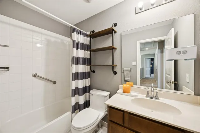 a bathroom with a sink a toilet a mirror and shower