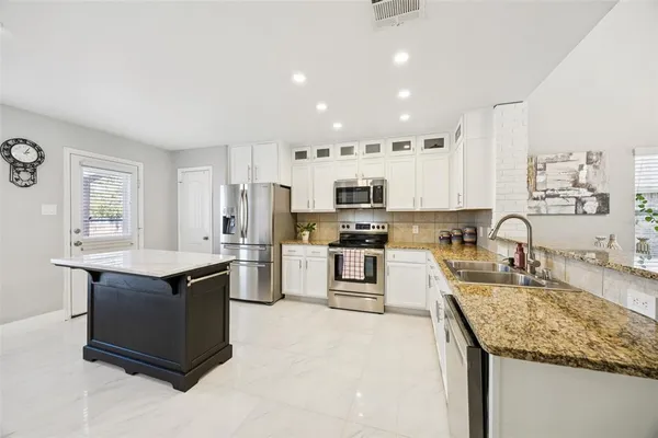 a kitchen with stainless steel appliances granite countertop a sink stove and refrigerator