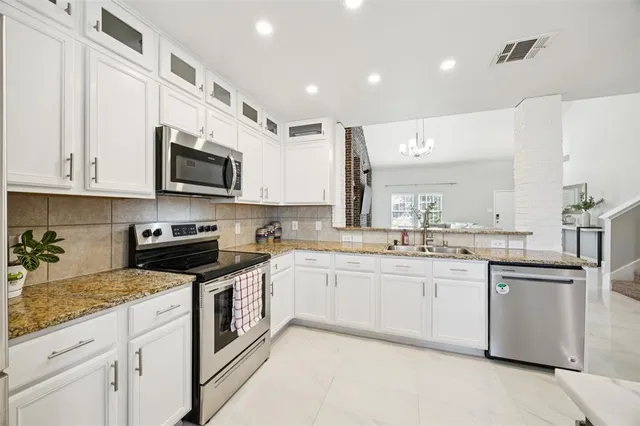a kitchen with stainless steel appliances granite countertop a sink and stove top oven