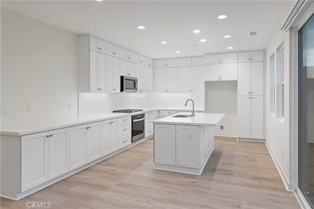 a kitchen with white cabinets appliances and sink