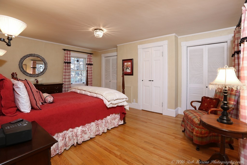 9 Woodside Road Topsfield, MA 01983 - Photo 16 of 27 a bedroom with bed and a chandelier