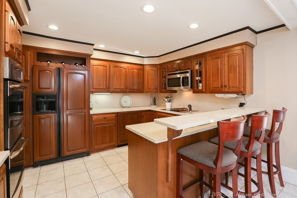 9 Woodside Road Topsfield, MA 01983 - Photo 3 of 27 a kitchen with stainless steel appliances granite countertop a table chairs sink refrigerator and cabinets