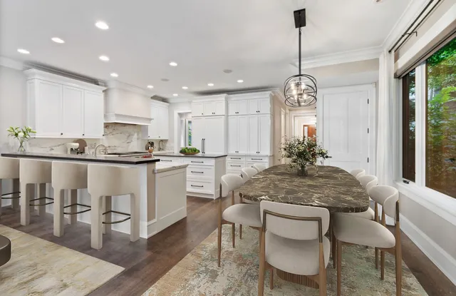 a kitchen with kitchen island granite countertop a counter space dining table and stainless steel appliances