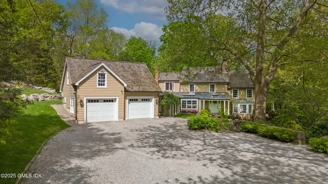 a front view of a house with a yard and trees