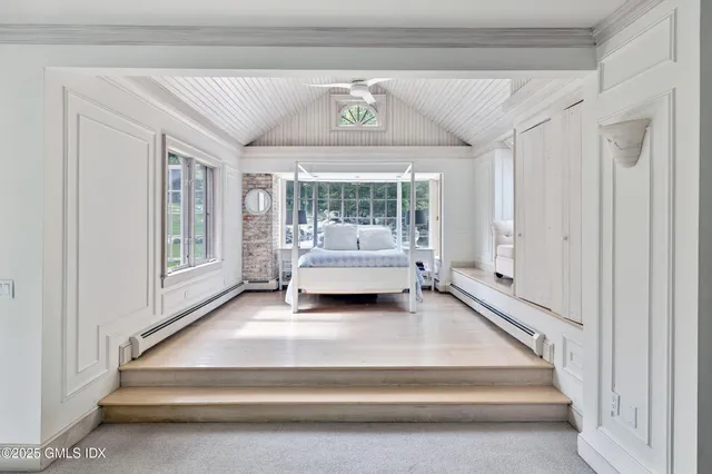 a bedroom with a bed and a large window