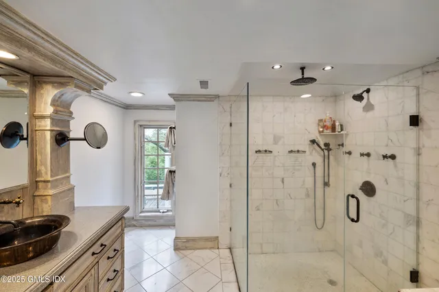 a bathroom with a granite countertop shower a sink and a mirror