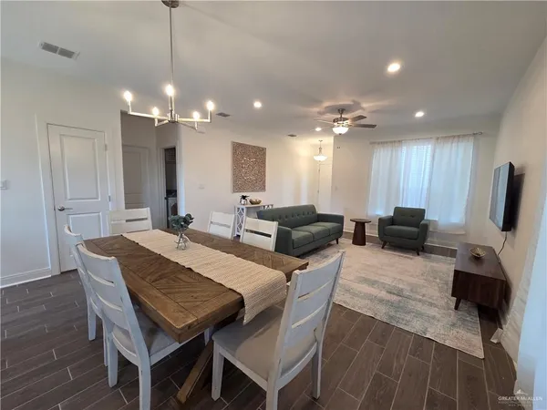 a living room with furniture a flat screen tv and kitchen view