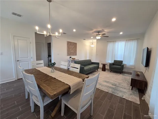 a living room with furniture a flat screen tv and kitchen view
