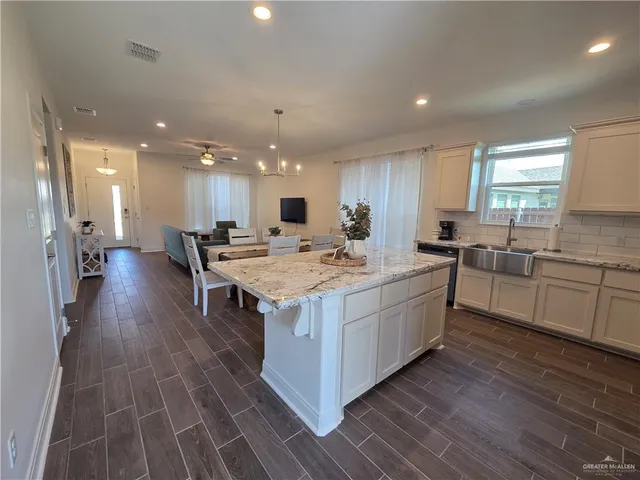 a kitchen with a stove a sink a refrigerator and cabinets