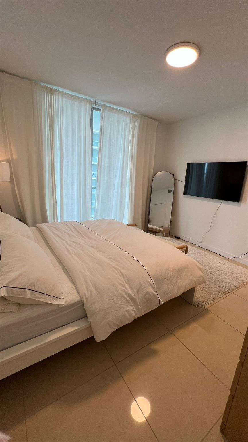 79 Southwest 12th Street, Unit 2908S Miami, FL 33130 - Photo 14 of 29 a large bed sitting in a bedroom next to a window