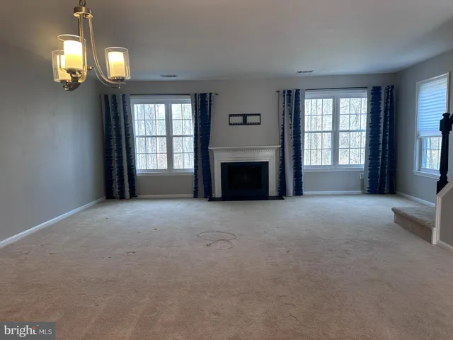 a view of a livingroom with a fireplace window and chair