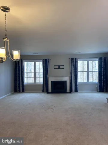 a view of an empty room with a fireplace and a window