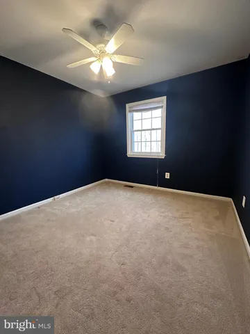en empty room with windows and chandelier fan