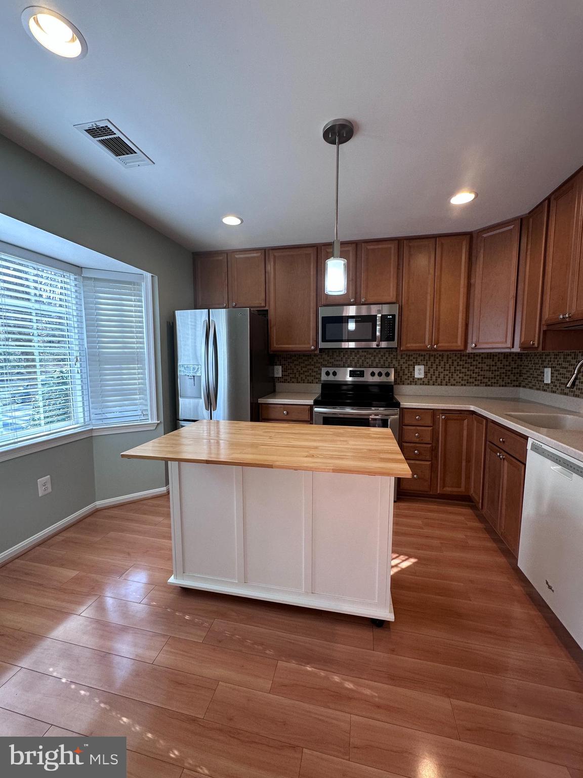 5832 1st Landing Way, Unit 137 Burke, VA 22015 - Photo 7 of 30 a large kitchen with kitchen island a large counter top space a sink stainless steel appliances and cabinets