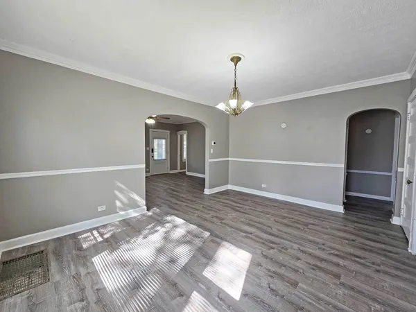a view of a livingroom with wooden floor and kitchen space