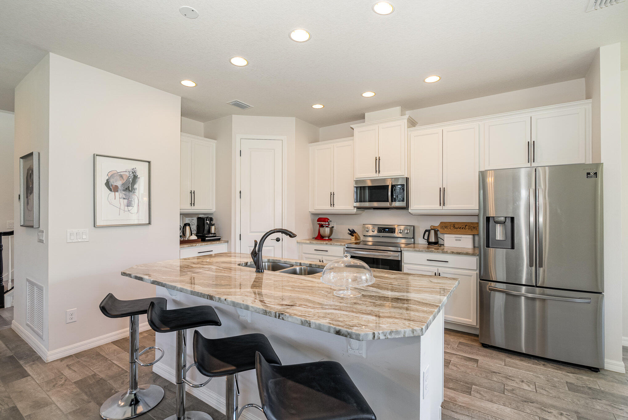 3179 Ribbon Grass Drive Melbourne, FL 32940 - Photo 13 of 52 a kitchen with kitchen island a refrigerator stove and white cabinets